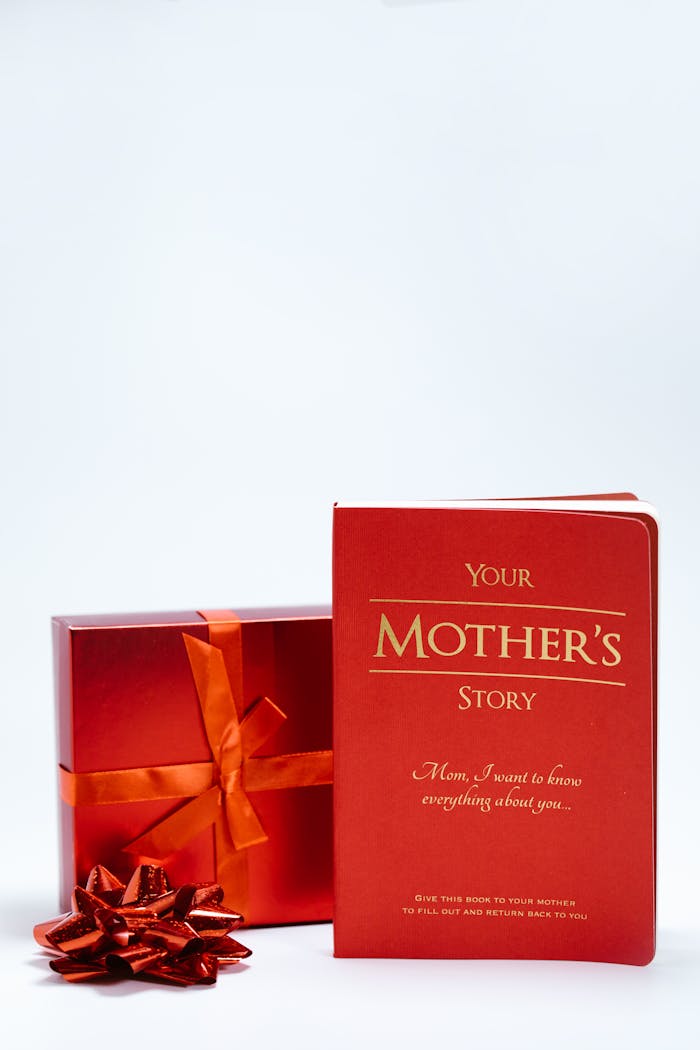 Red gift box and book titled 'Your Mother's Story' for Mother's Day on white background.
